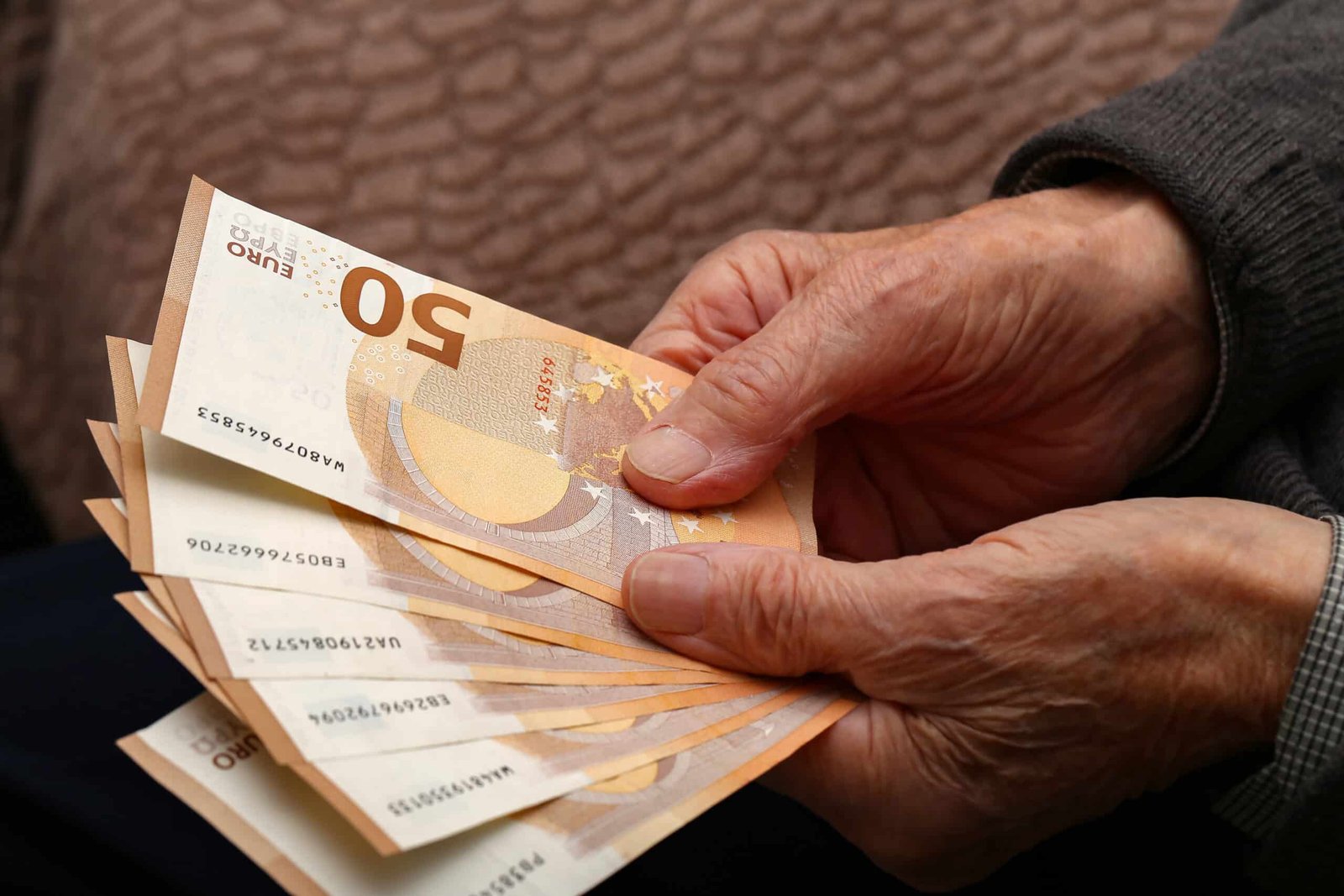 closeup shot of money in the hands of an old man