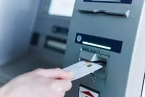 person insert card to automated teller machine. cashing non cash money by individual.